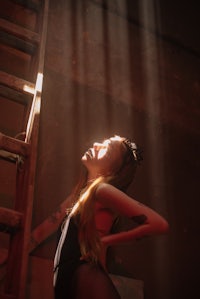 a woman leaning against a ladder