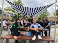 a group of people sitting at a picnic table