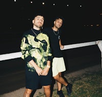 two men standing next to a fence