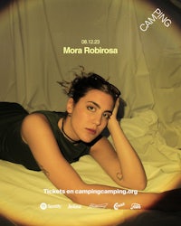 a woman is laying on a bed with a poster